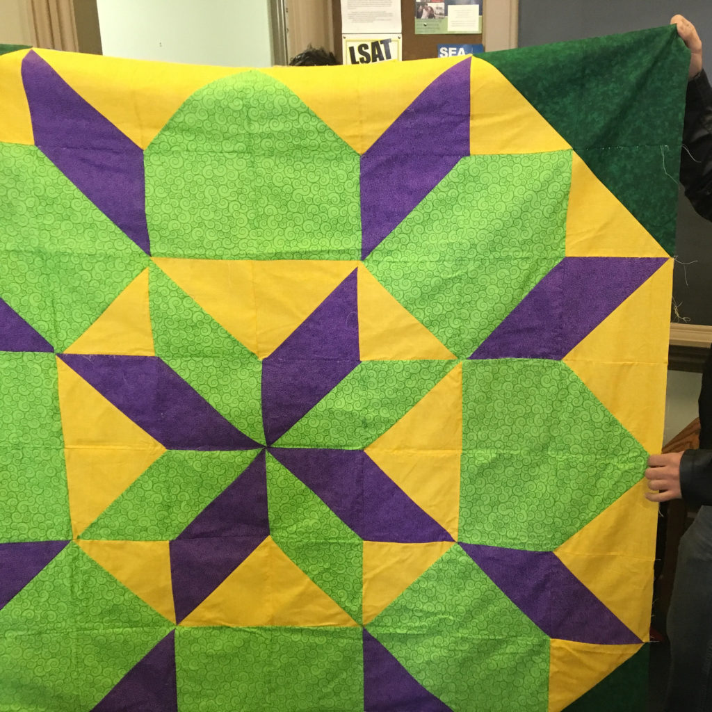 a green, purple, and yellow star quilt