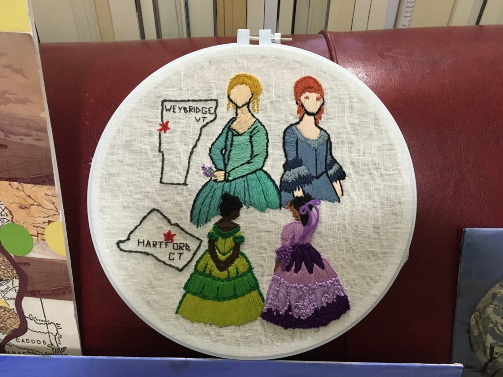 an embroidered picture of four women from the 19th century